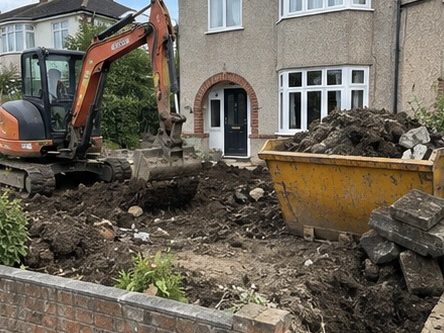 A front garden dug out to formation beside a semi detached house, the spoil going straight into a skip
